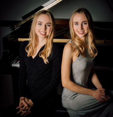 a portrait photo of the pianists - two blondes in their 20s